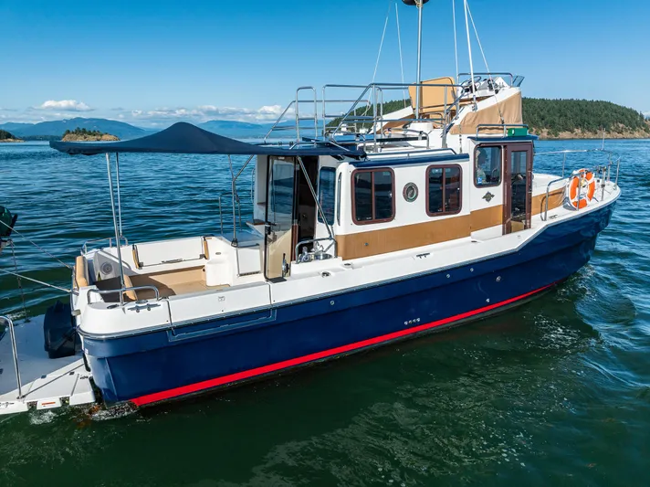 The Western Yacht Photos Pics 2014 Ranger Tugs R-31CB boat on calm water with scenic background.