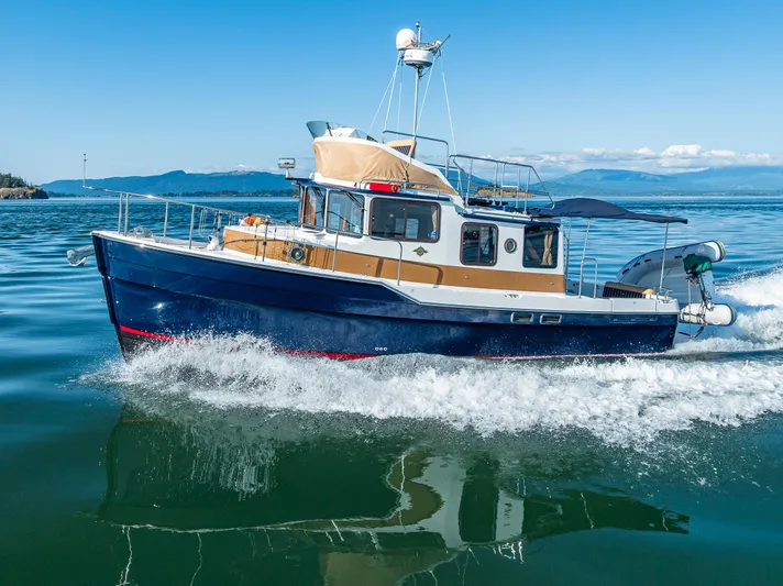 The Western Yacht Photos Pics 2014 Ranger Tugs R-31CB cruising on clear blue water under a sunny sky.