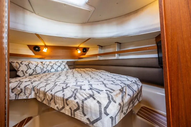 The Western Yacht Photos Pics Cozy cabin interior of 2014 Ranger Tugs R-31CB with patterned bedding and warm lighting.