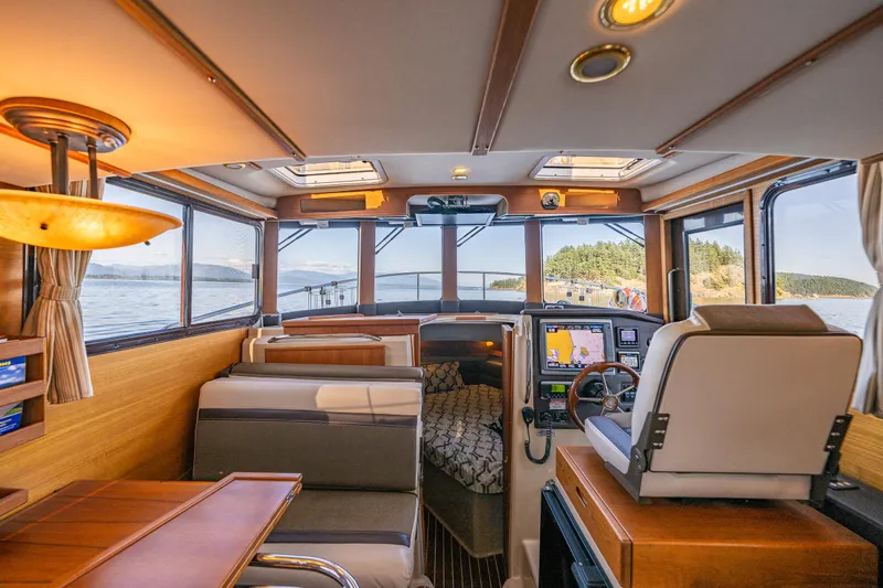 The Western Yacht Photos Pics 2014 Ranger Tugs R-31CB interior with helm, seating, and scenic water view.