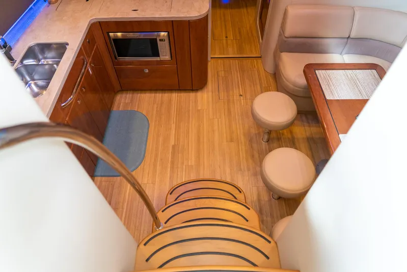  Yacht Photos Pics Interior of 2016 Formula 45 Yacht with kitchen and seating area, featuring wooden flooring.