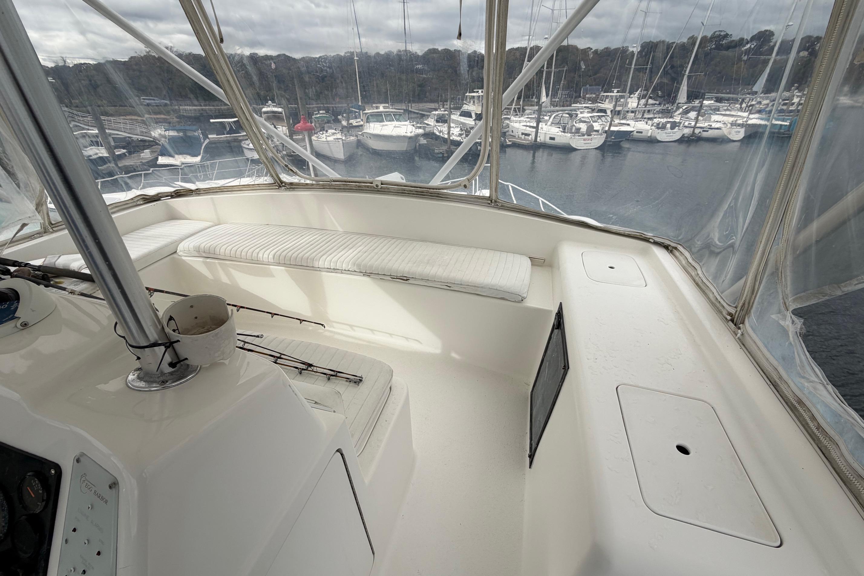 2001 Egg Harbor 42 SportYacht interior with marina view, featuring white seating and helm controls.