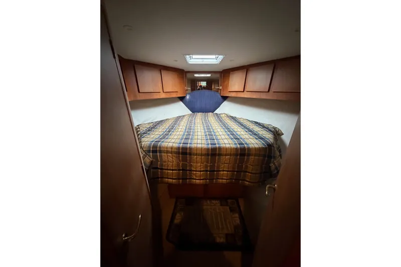 Ronnie H Yacht Photos Pics Cozy cabin interior of 2001 Egg Harbor 42 SportYacht with plaid bedding and wooden cabinets.