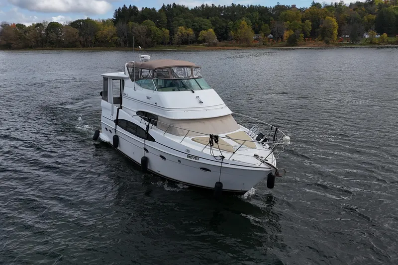  Yacht Photos Pics 2002 Carver 466 Motor Yacht cruising on a scenic lake with forested shoreline.