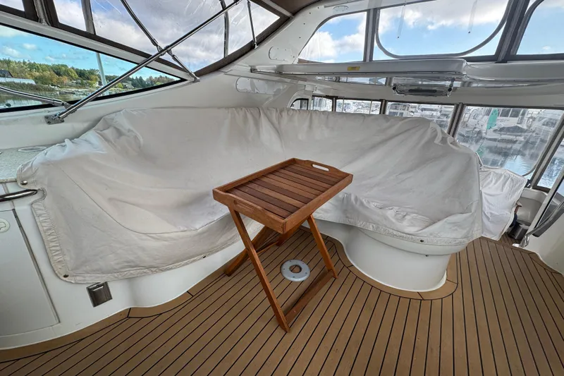  Yacht Photos Pics Interior of 2002 Carver 466 Motor Yacht with covered seating and wooden tray table.