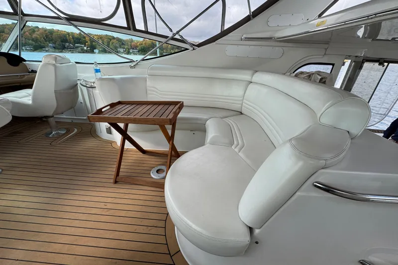  Yacht Photos Pics Luxurious 2002 Carver 466 Motor Yacht interior with white seating and wooden table.