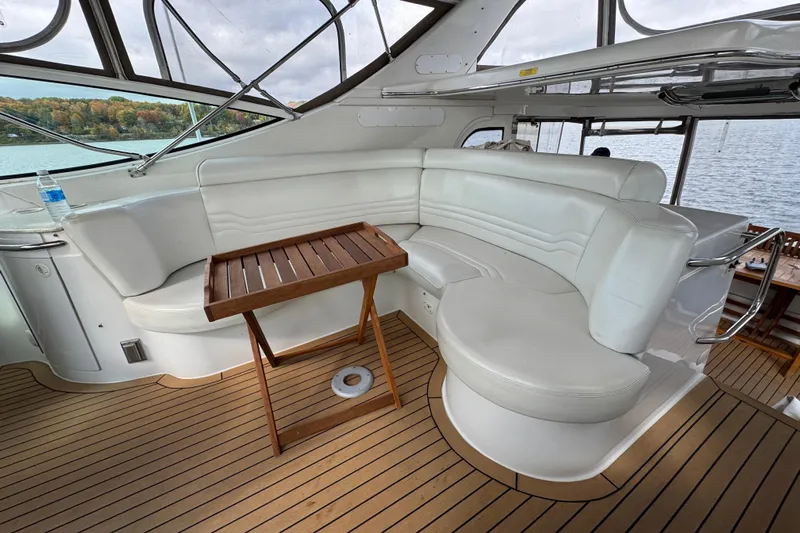  Yacht Photos Pics Luxurious seating area on 2002 Carver 466 Motor Yacht with wooden table and scenic lake view.