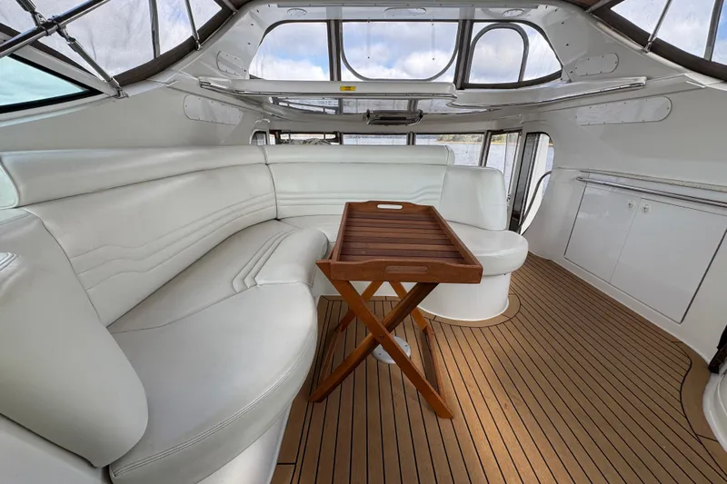  Yacht Photos Pics Luxurious interior of 2002 Carver 466 Motor Yacht with white seating and wooden table.