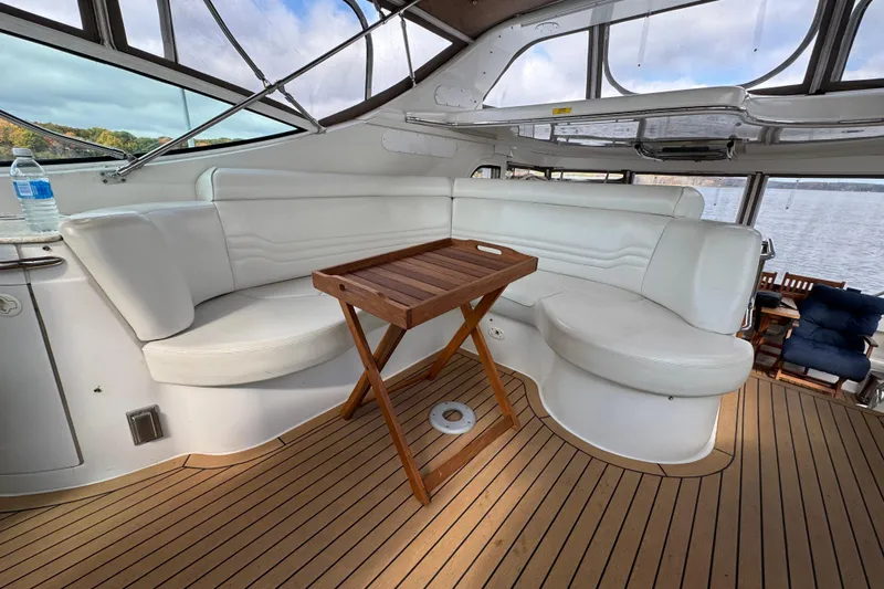  Yacht Photos Pics Luxurious interior of 2002 Carver 466 Motor Yacht with white seating and wooden table.