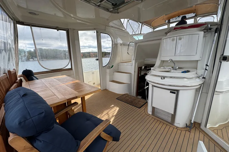  Yacht Photos Pics 2002 Carver 466 Motor Yacht interior with dining area and kitchenette, overlooking serene waters.