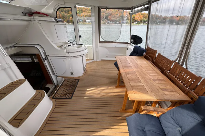  Yacht Photos Pics Spacious deck of 2002 Carver 466 Motor Yacht with wooden table and seating.