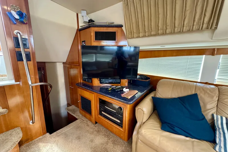  Yacht Photos Pics Interior of 2002 Carver 466 Motor Yacht with TV, beige sofa, and wooden cabinetry.