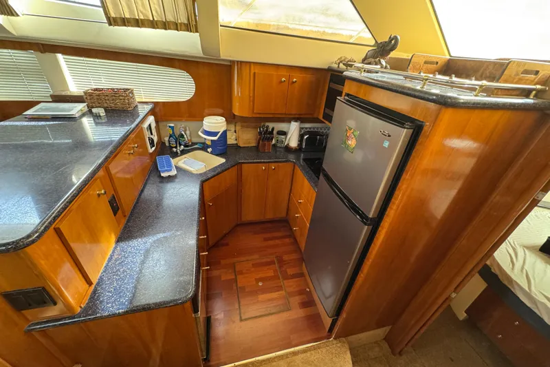  Yacht Photos Pics 2002 Carver 466 Motor Yacht kitchen with wood cabinetry and modern appliances.