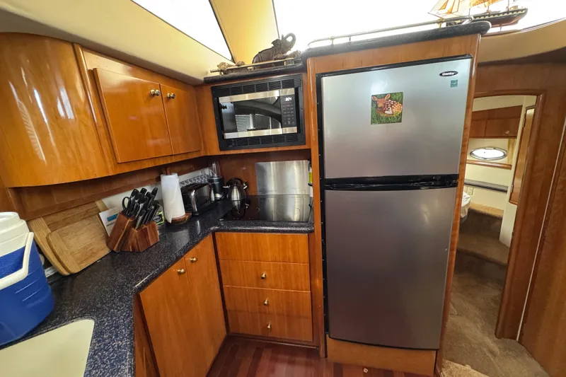  Yacht Photos Pics Interior of 2002 Carver 466 Motor Yacht kitchen with wooden cabinets and stainless steel appliances.