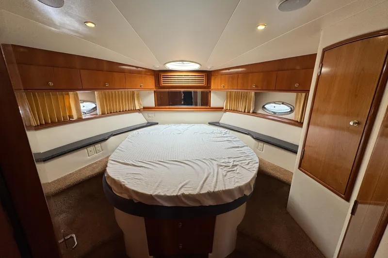  Yacht Photos Pics Luxurious interior of 2002 Carver 466 Motor Yacht with cozy bed and wooden cabinetry.