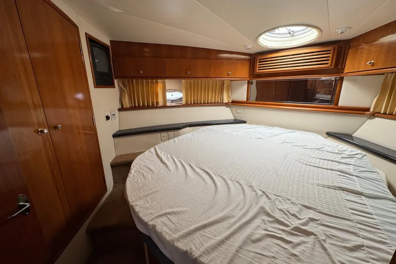  Yacht Photos Pics Interior cabin of 2002 Carver 466 Motor Yacht with bed and wooden cabinetry.