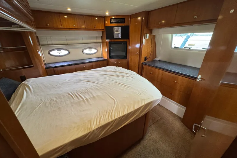  Yacht Photos Pics Luxurious interior of 2002 Carver 466 Motor Yacht with cozy bedroom and wood finishes.