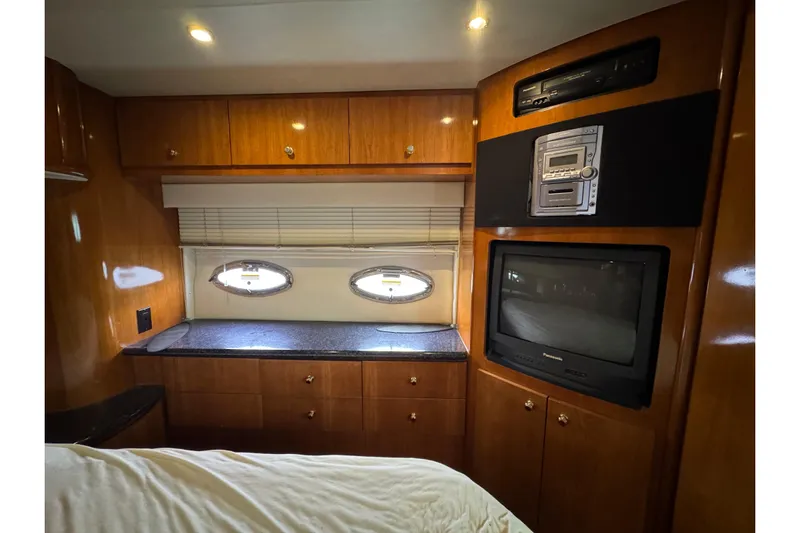  Yacht Photos Pics 2002 Carver 466 Motor Yacht interior with wood cabinetry, TV, and porthole windows.