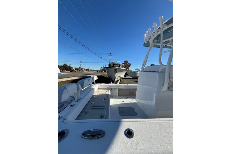  Yacht Photos Pics 2026 Yellowfin 26 Hybrid boat interior with seating and storage, under clear blue sky.