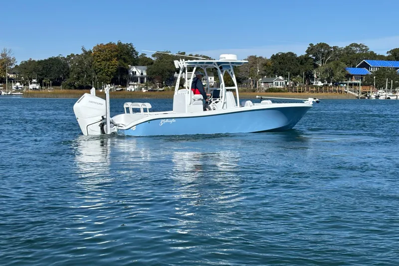  Yacht Photos Pics 2026 Yellowfin 26 Hybrid boat cruising on a calm lake with scenic shoreline.