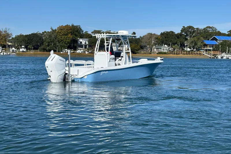  Yacht Photos Pics 2026 Yellowfin 26 Hybrid boat on calm water near shoreline.