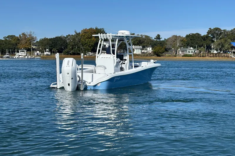  Yacht Photos Pics 2026 Yellowfin 26 Hybrid boat on calm water, surrounded by scenic shoreline.