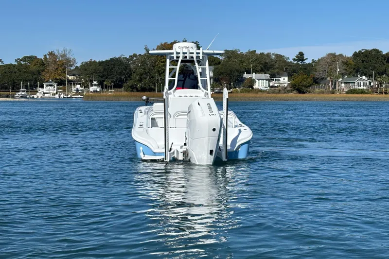 Yacht Photos Pics 2026 Yellowfin 26 Hybrid boat on calm water with scenic shoreline background.