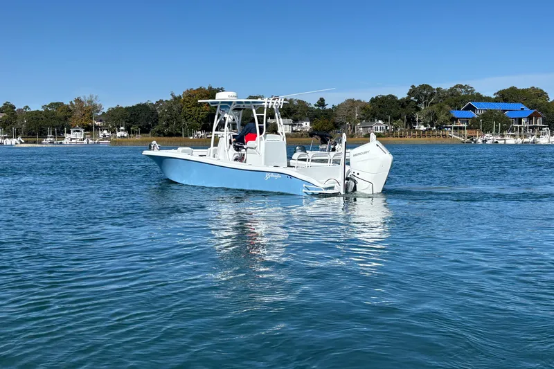  Yacht Photos Pics 2026 Yellowfin 26 Hybrid boat on calm water, with scenic shoreline background.