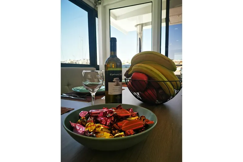 Eagle Yacht Photos Pics Bali 4.8 yacht interior with wine, fruit, and chocolates on a table, 2022 model.