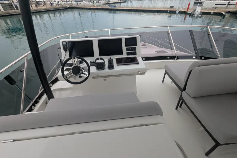  Yacht Photos Pics 2024 Prestige M48 yacht helm with modern controls and seating, docked at marina.