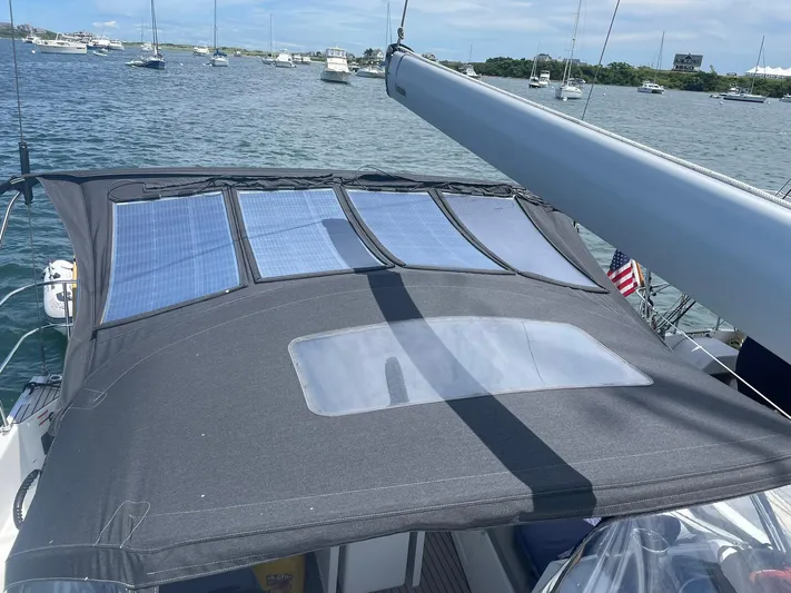 Shaz Yacht Photos Pics Jeanneau Sun Odyssey 410 (2020) with solar panels on deck, anchored in a scenic bay.