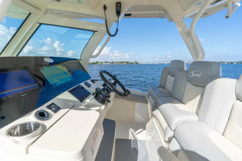  Yacht Photos Pics 2023 Scout 355 LXF boat interior with modern helm and seating, overlooking serene waters.