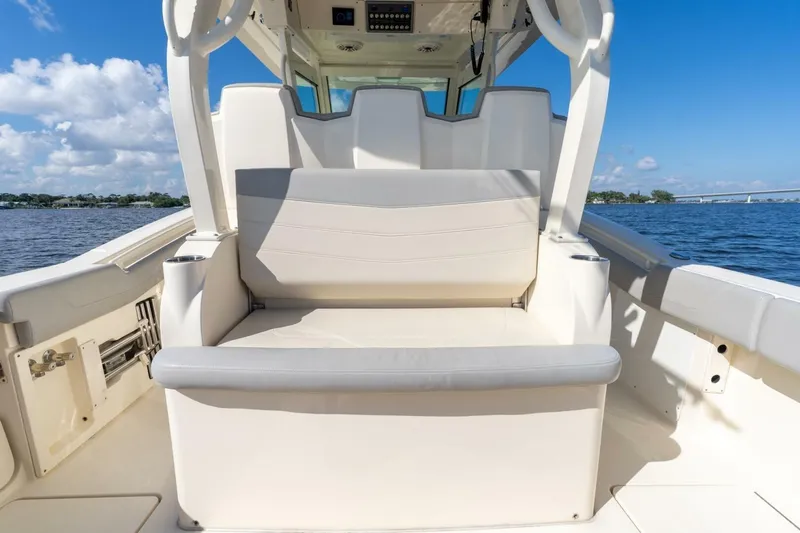  Yacht Photos Pics 2023 Scout 355 LXF boat interior with seating, on a sunny day by the water.