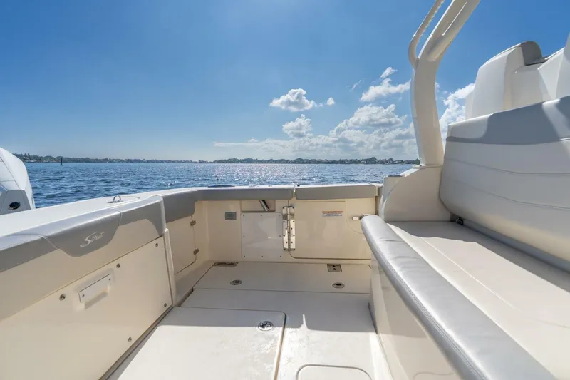  Yacht Photos Pics 2023 Scout 355 LXF boat interior with seating, overlooking calm waters and blue sky.