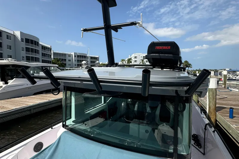  Yacht Photos Pics 2024 Axopar 37XC boat docked, featuring roof-mounted equipment and modern design.