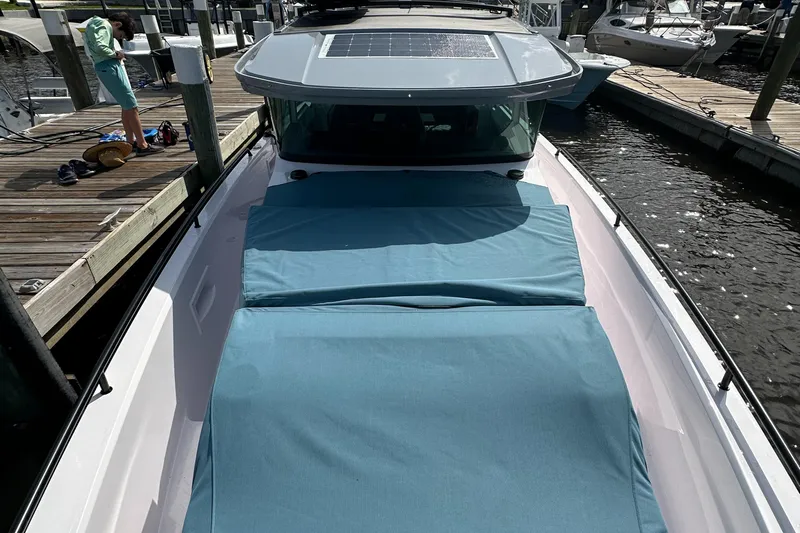  Yacht Photos Pics 2024 Axopar 37XC boat docked, featuring blue sun pads and a sleek design.