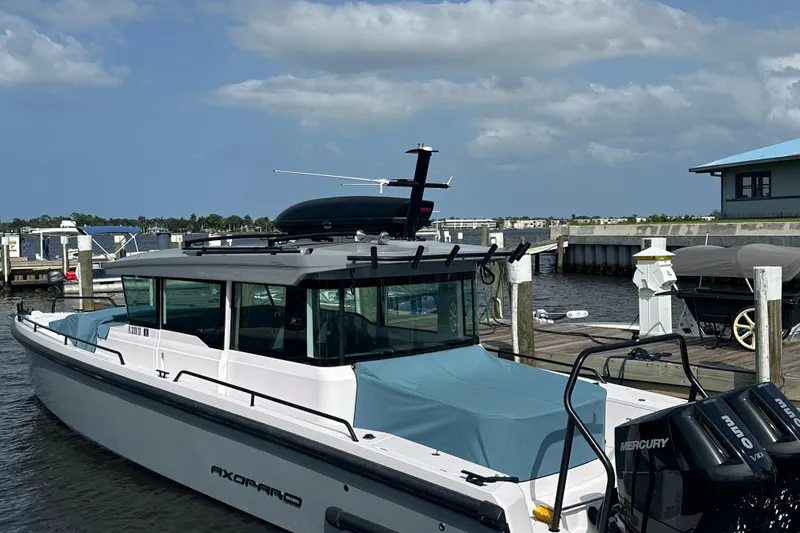  Yacht Photos Pics 2024 Axopar 37XC boat docked with Mercury engines, under a partly cloudy sky.