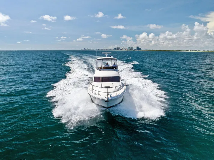 Megusta Yacht Photos Pics 2007 Sea Ray 44 Sedan Bridge cruising on open water with city skyline in background.