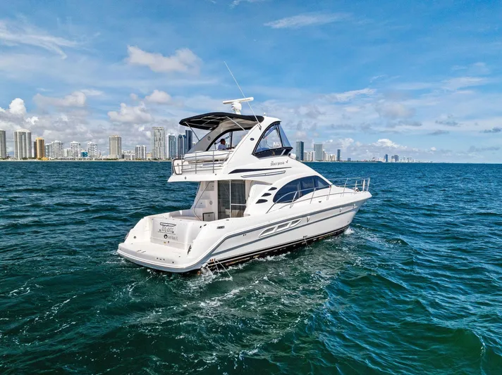 Megusta Yacht Photos Pics 2007 Sea Ray 44 Sedan Bridge yacht cruising near city skyline.