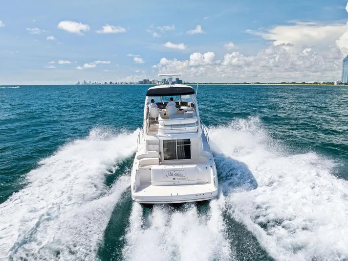 Megusta Yacht Photos Pics 2007 Sea Ray 44 Sedan Bridge cruising on open water with city skyline in background.