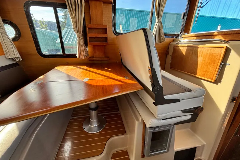  Yacht Photos Pics 2015 Ranger Tugs R-31 CB interior with wooden table and seating area.