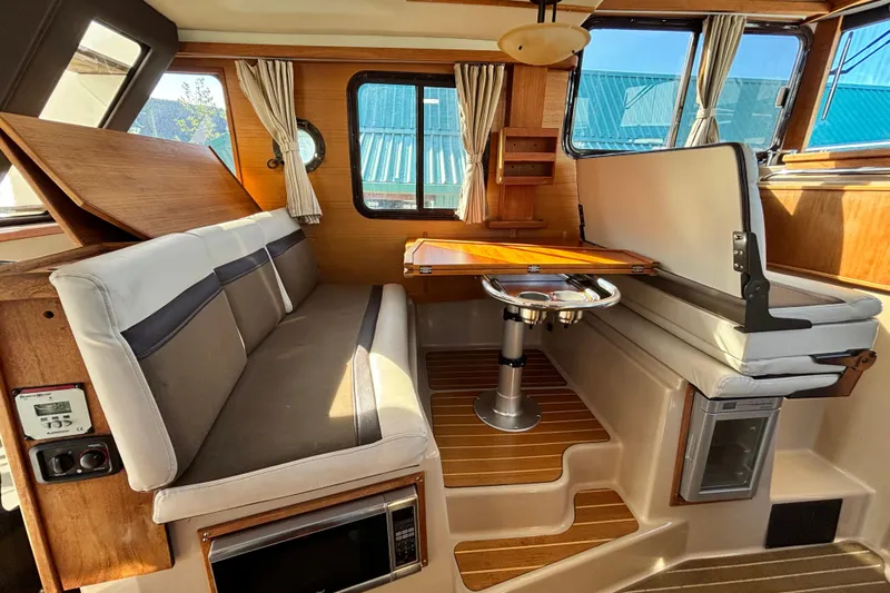  Yacht Photos Pics Interior of 2015 Ranger Tugs R-31 CB with seating, table, and wood accents.