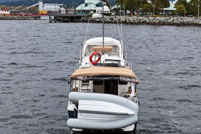  Yacht Photos Pics 2015 Ranger Tugs R-31 CB boat on water, dock and buildings in background.