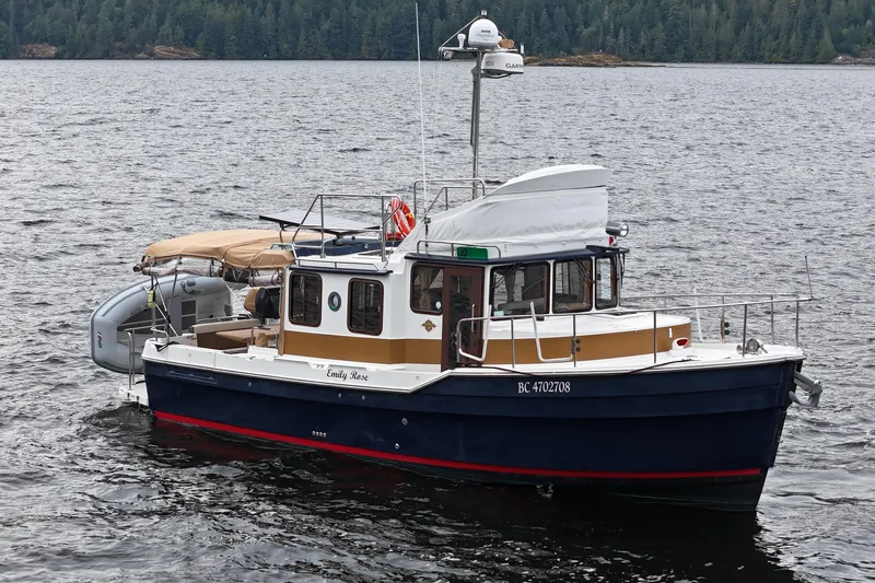  Yacht Photos Pics 2015 Ranger Tugs R-31 CB boat on a calm lake with forested background.