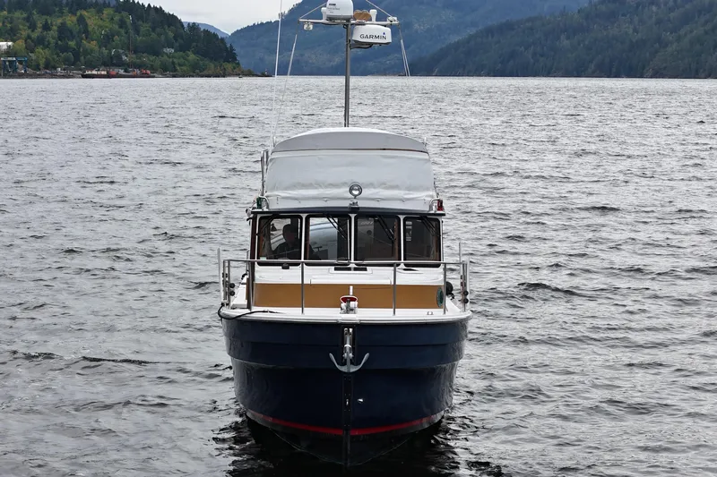  Yacht Photos Pics 2015 Ranger Tugs R-31 CB boat on a scenic lake with forested hills.