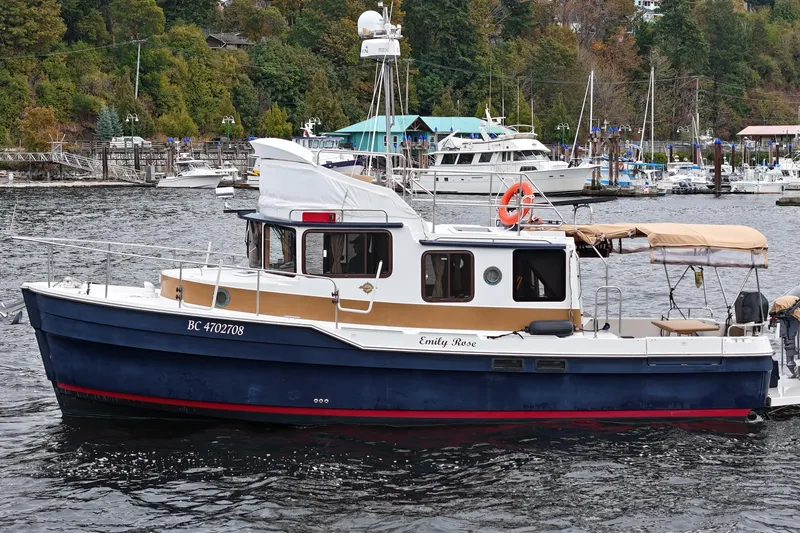  Yacht Photos Pics 2015 Ranger Tugs R-31 CB boat on water, surrounded by lush greenery and marina.