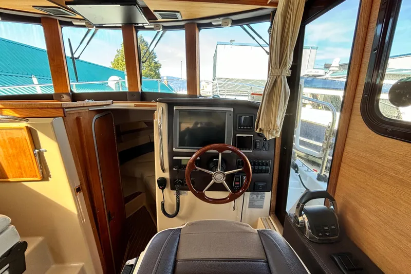  Yacht Photos Pics Interior helm of 2015 Ranger Tugs R-31 CB with steering wheel and navigation controls.