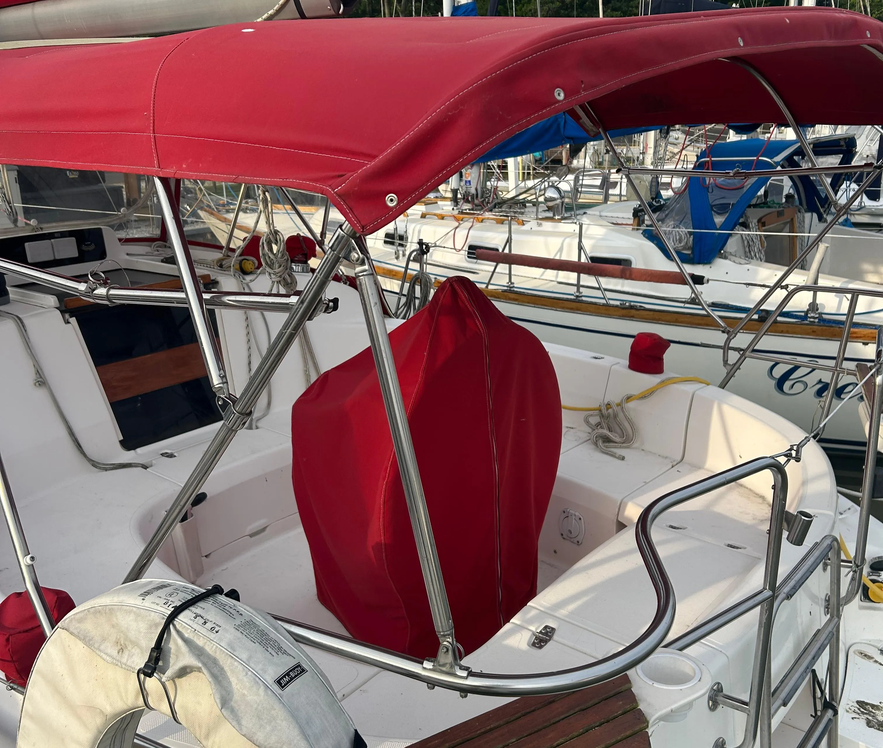 Sailboat cockpit with red canopy, Hunter 336, 1996 model, docked at marina.