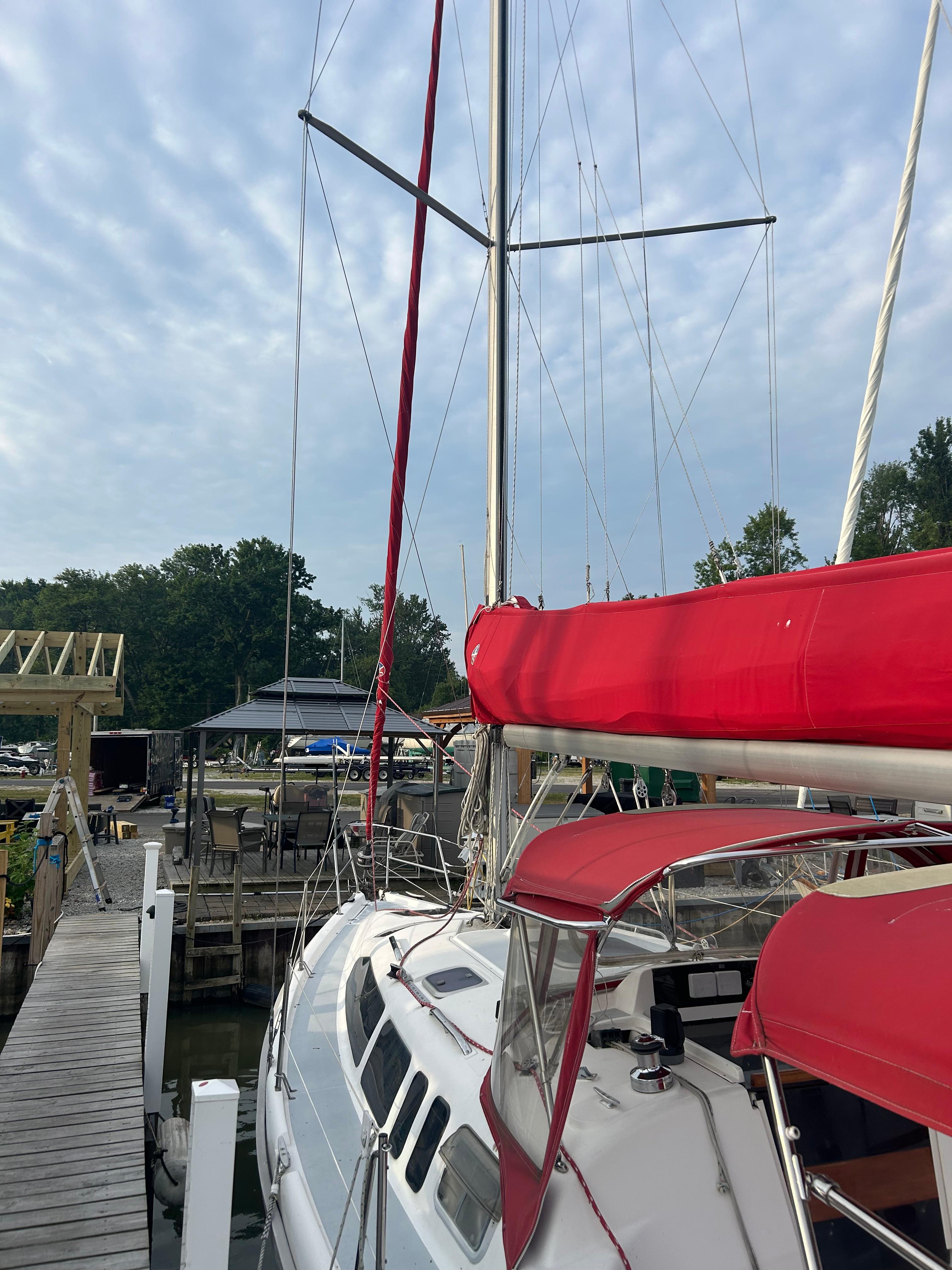 Sailboat docked at marina, Hunter 336 model, 1996, with red sail cover and canopy.