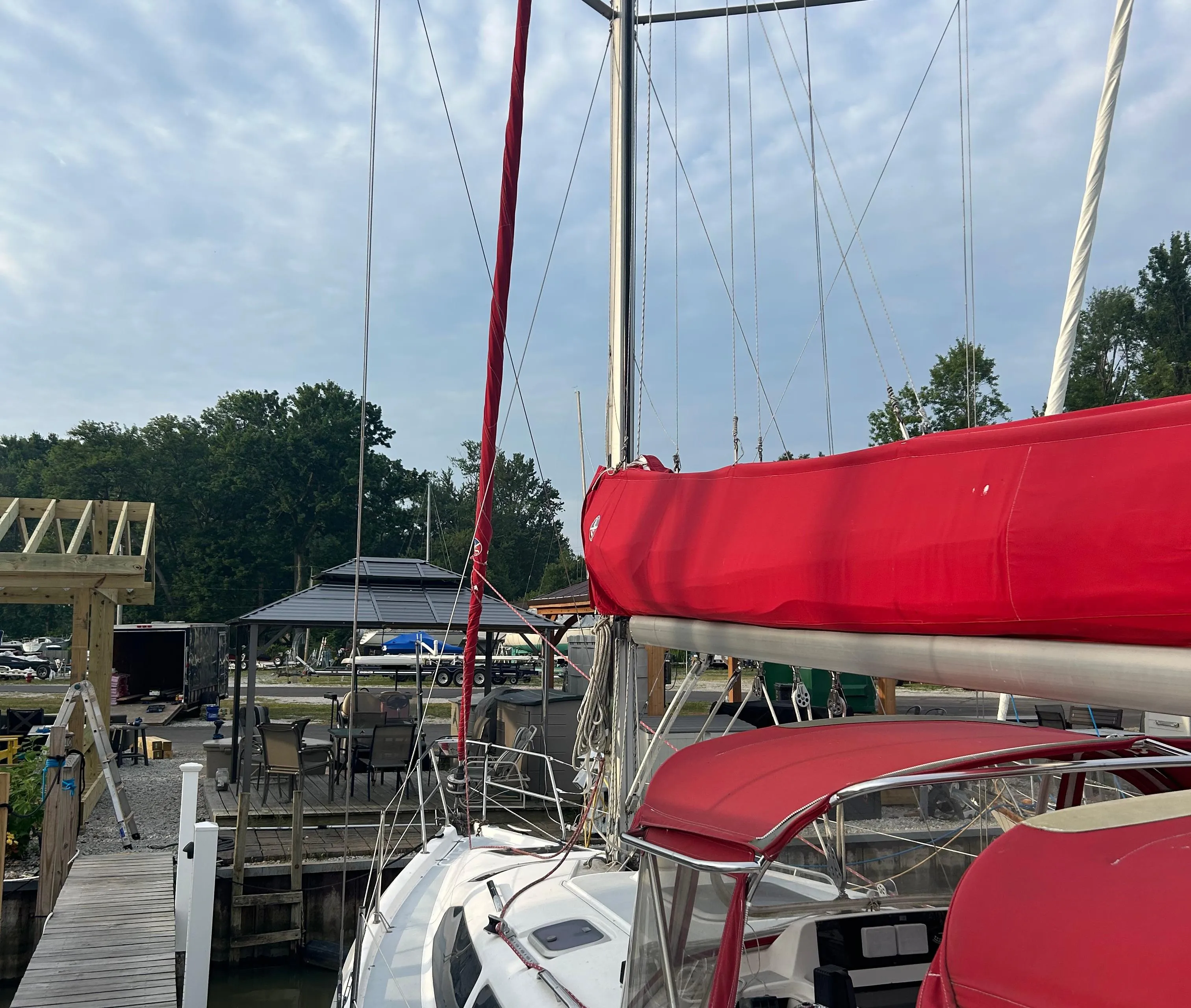Sailboat docked at marina, Hunter 336 model, 1996, with red sail cover and canopy.